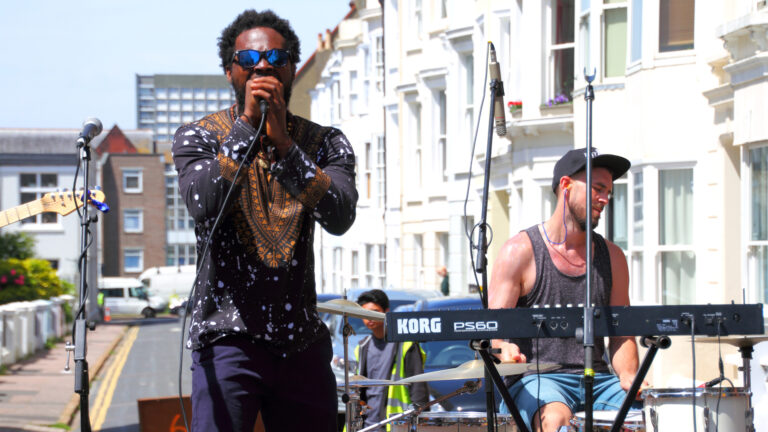 GiwHa singing into a microphone at an outdoor music festival